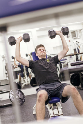 Student lifting weights at WVU Potomac State College's J. Edward Kelley Rec Center Complex